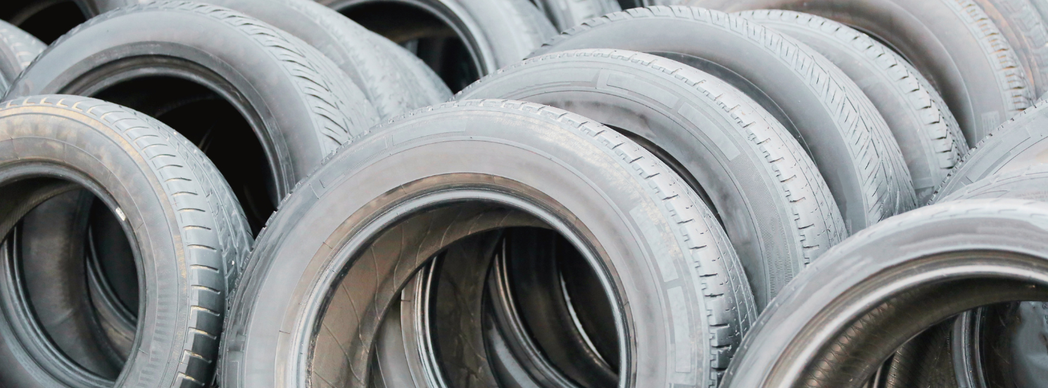 Neat pile of off-the-rim passenger car tyre casings on a warehouse floor